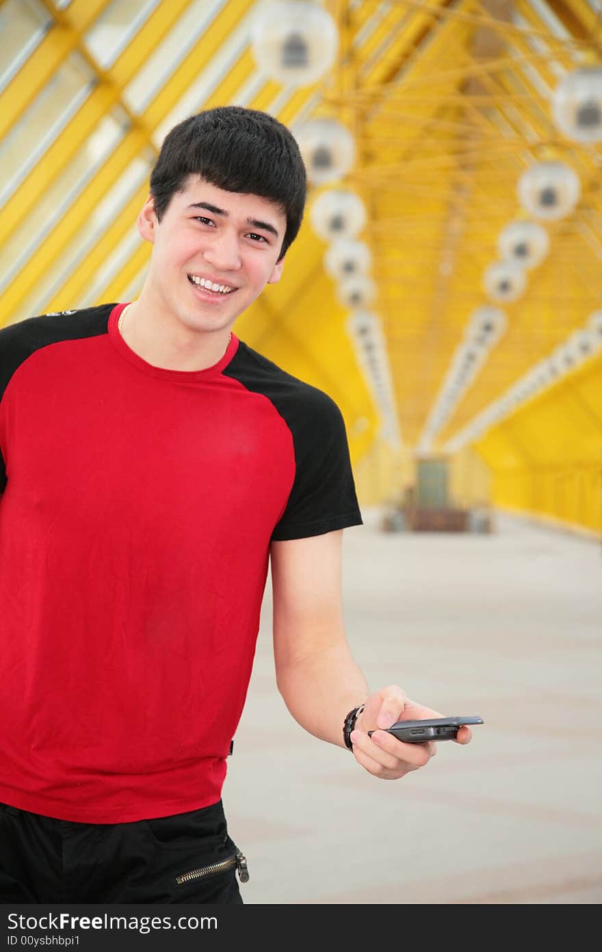 Young man with cell phone on footbridge