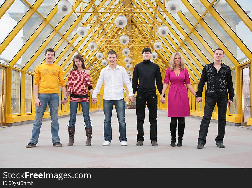 Group of friends it stand taking hands on footbridge