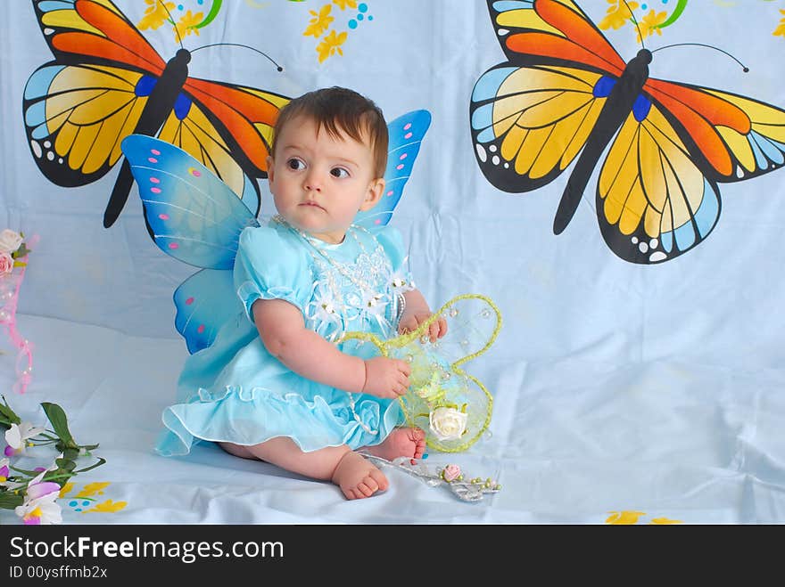 A picture of a sweet little girl in a fancy blue dress with butterfly wings. A picture of a sweet little girl in a fancy blue dress with butterfly wings