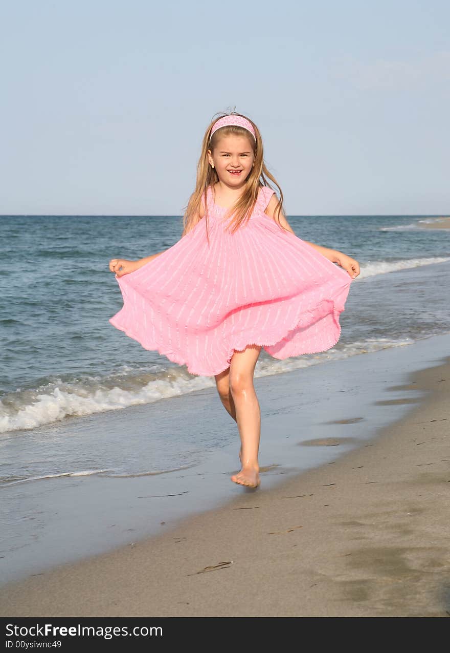 Little girl running at the sandy beach. Little girl running at the sandy beach