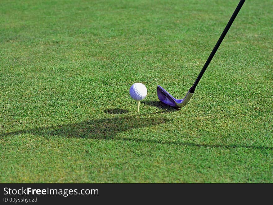 Golfball in front of the green grass hole. Golfball in front of the green grass hole