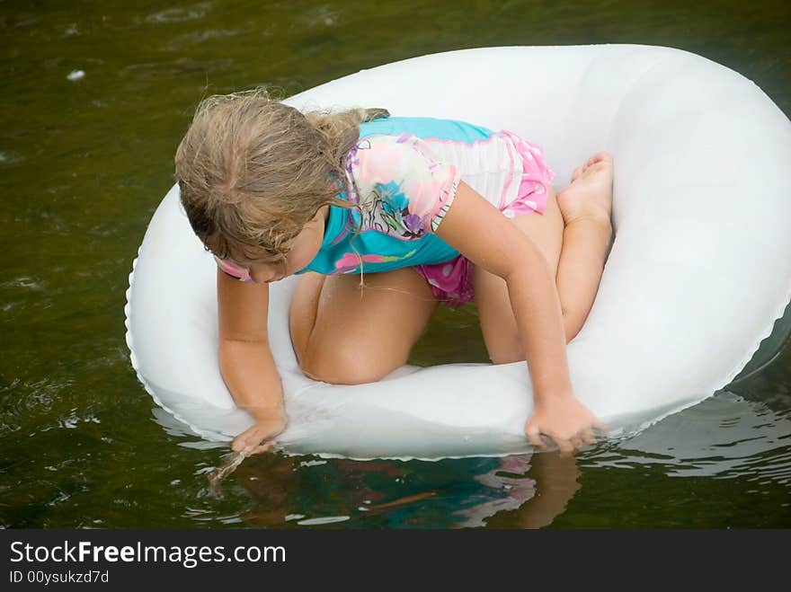 Young girl playing in a tube on the water. Young girl playing in a tube on the water.