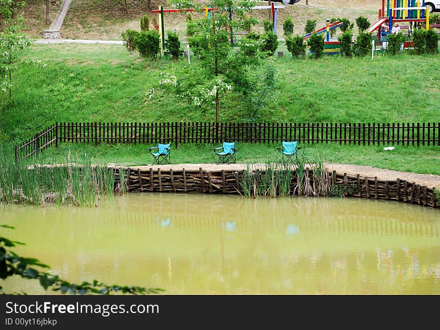 Folding blue chairs by muddy pond. Folding blue chairs by muddy pond