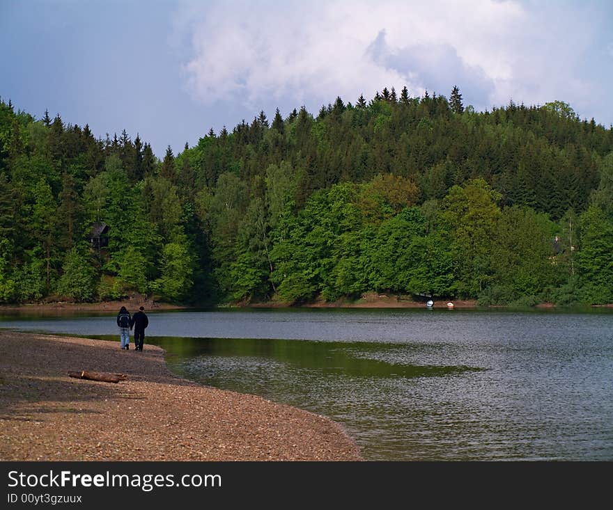 Two young people walking near lake. Two young people walking near lake