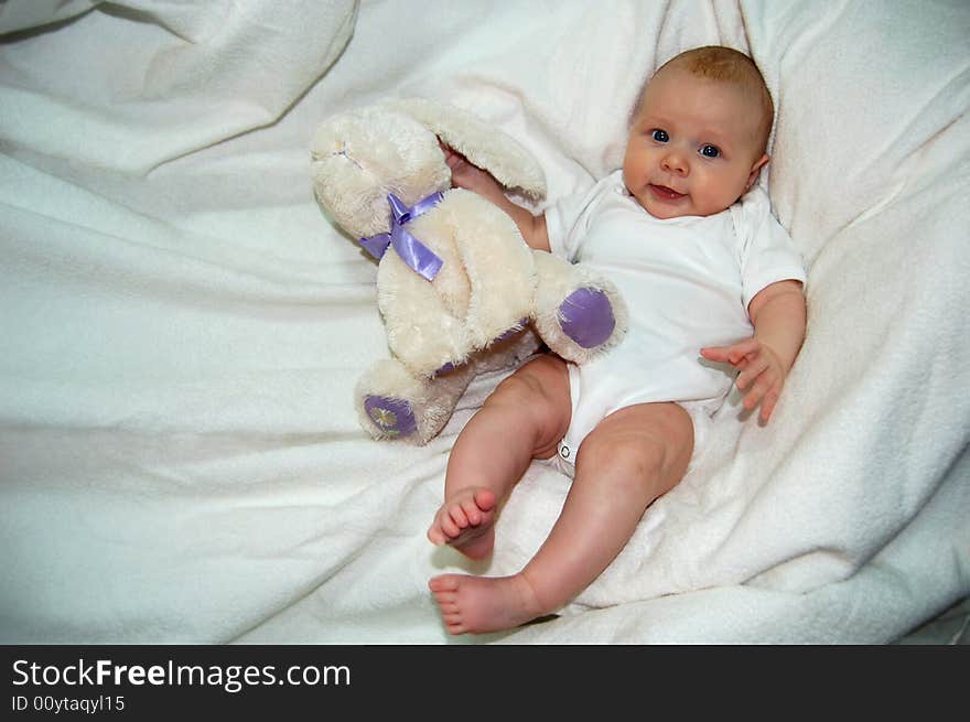 Lovely baby with  blue eyes, palming bunny - toy. Lovely baby with  blue eyes, palming bunny - toy