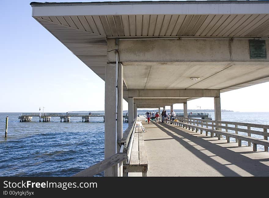 An old concrete fishing pier extending into the ocean. An old concrete fishing pier extending into the ocean