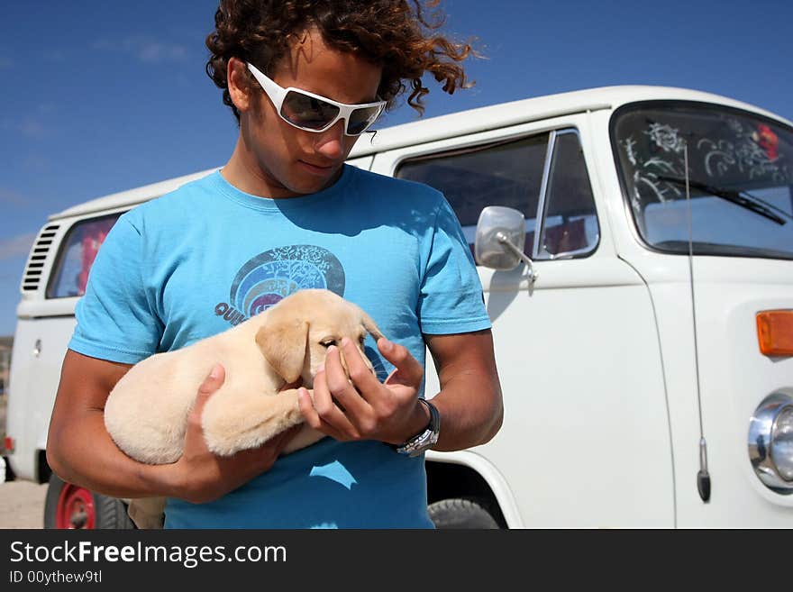 Young man holding his labrador puppy. Young man holding his labrador puppy