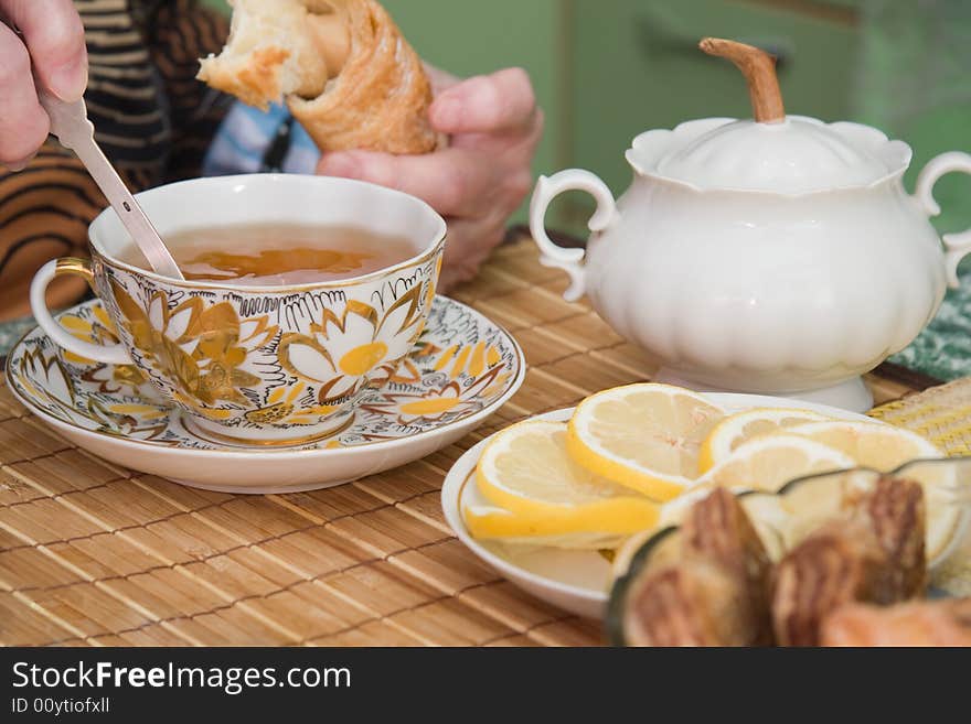 Senior woman drinks tea with sweet rolls