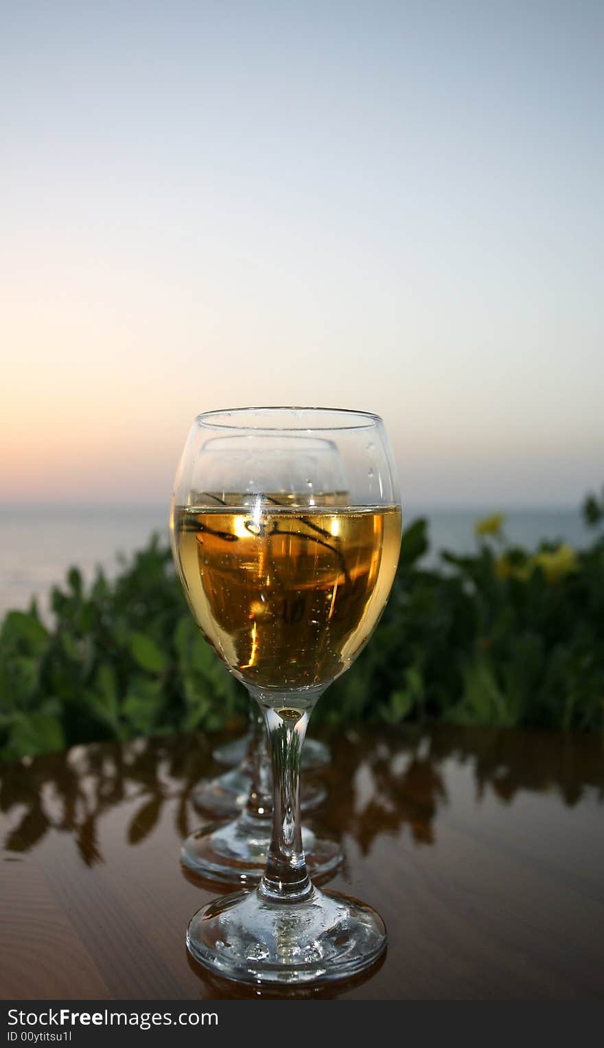 One glass of white wine on the sunrise in the sea