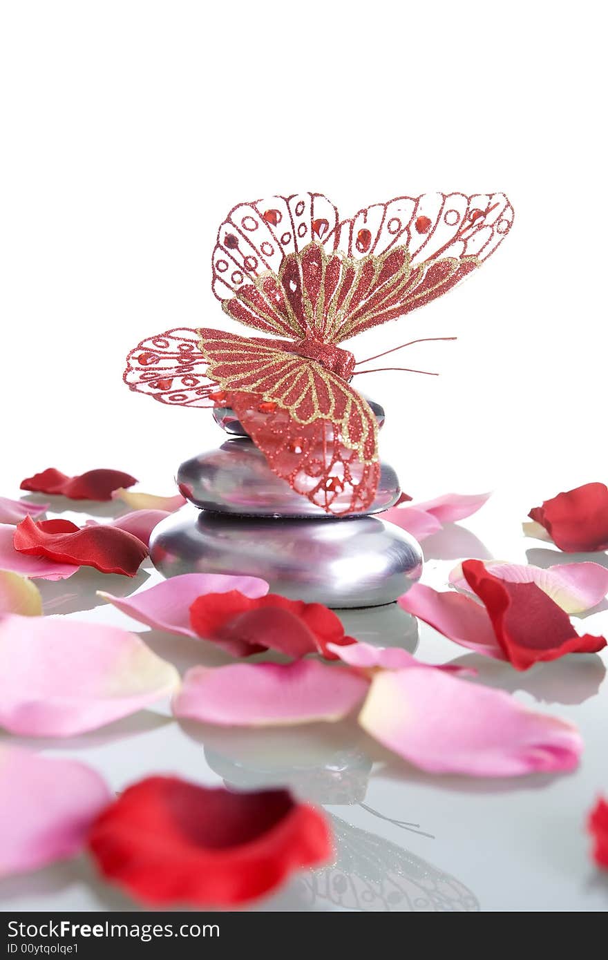 Pile of stones with rose petals and butterfly - spa and zen concept