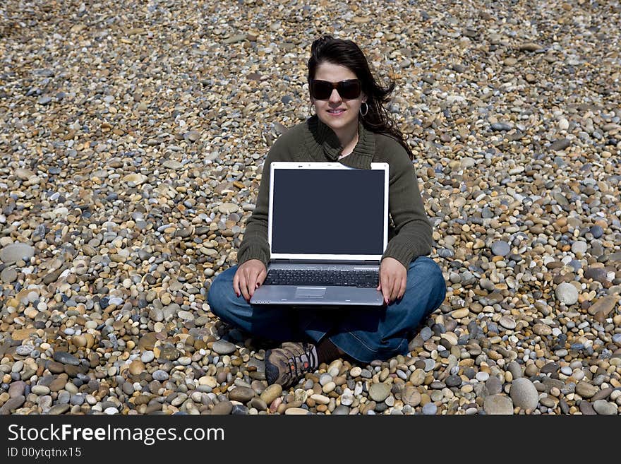 Young woman holding laptop computer in beach. Young woman holding laptop computer in beach