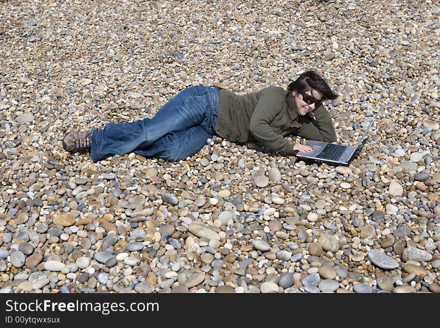 Young woman holding laptop computer in beach. Young woman holding laptop computer in beach