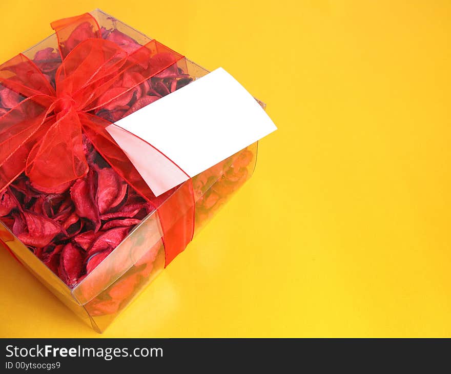 Red Potpourri gift with a white card, on a yellow background