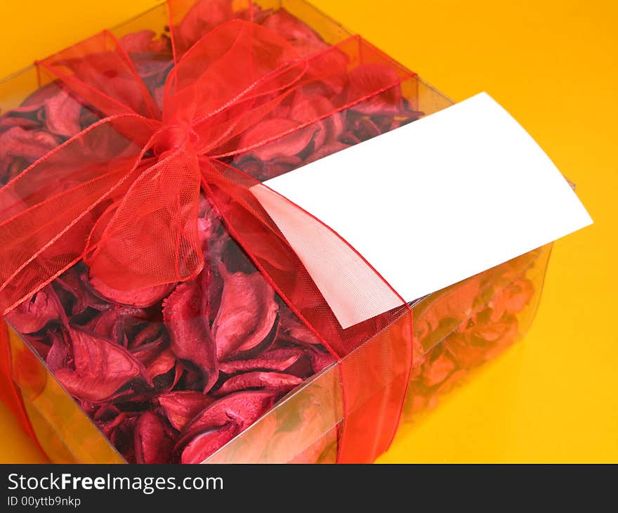 Red Potpourri gift with a white card, on a yellow background