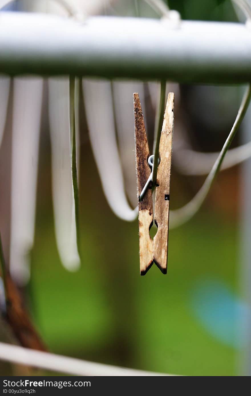 Single clothes pin hanging on clothes line with shallow depth of field. Single clothes pin hanging on clothes line with shallow depth of field