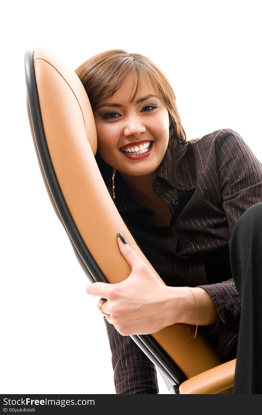 Cheerful young japanese girl sitting in armchair.