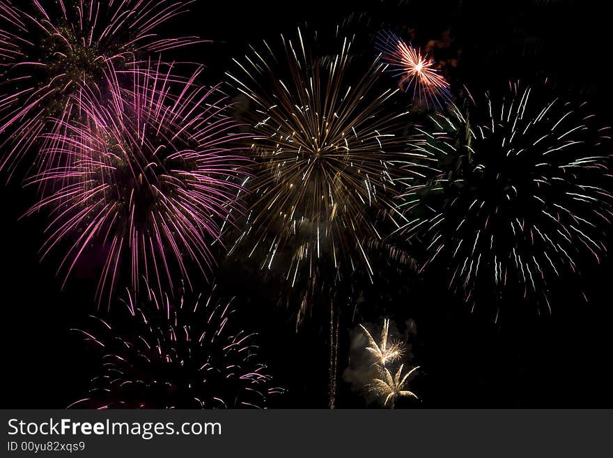 Fireworks display with several different colored fireworks exploding in the sky.