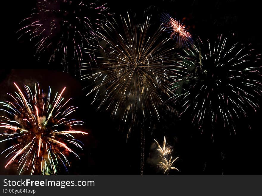 Fireworks display with several different colored fireworks exploding in the sky. Fireworks display with several different colored fireworks exploding in the sky.