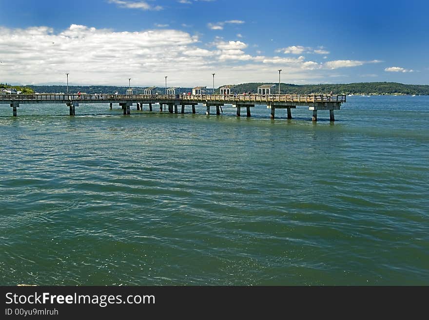 A long pier over the coean with blue skies. A long pier over the coean with blue skies