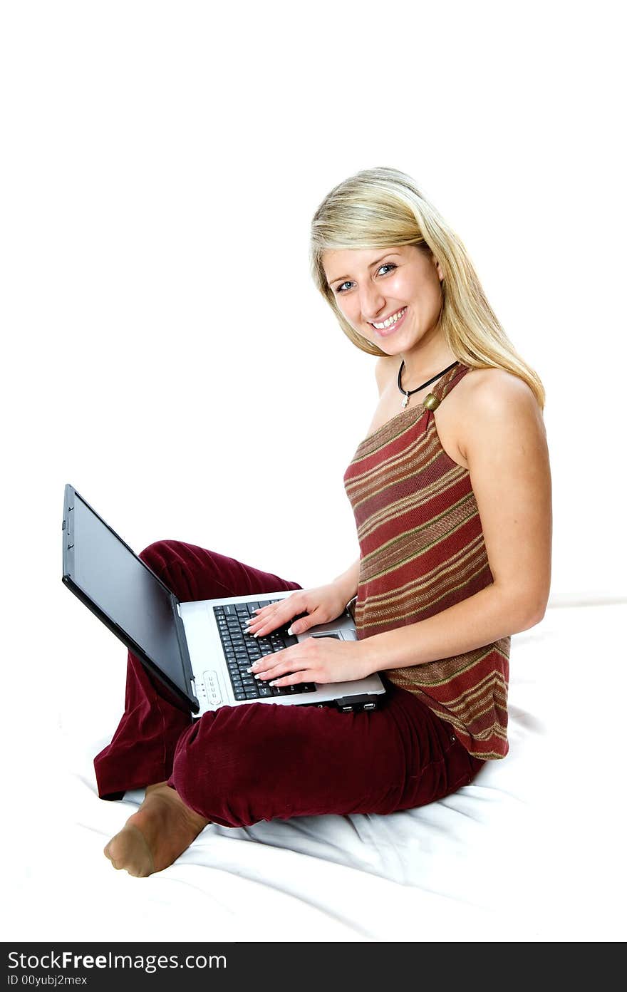 Beautiful girl with blonde hair using a laptop computer and smile. Shot with Nikon D3. Beautiful girl with blonde hair using a laptop computer and smile. Shot with Nikon D3.