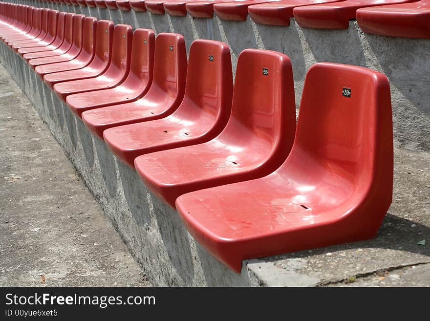 Empty red chairs in open-air arena