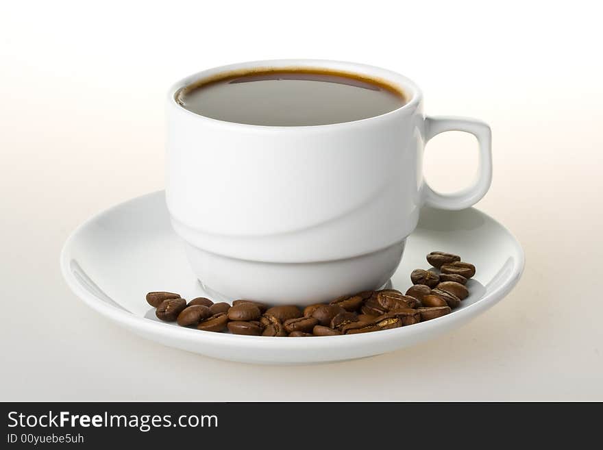 Boiled coffee in a cup and beans