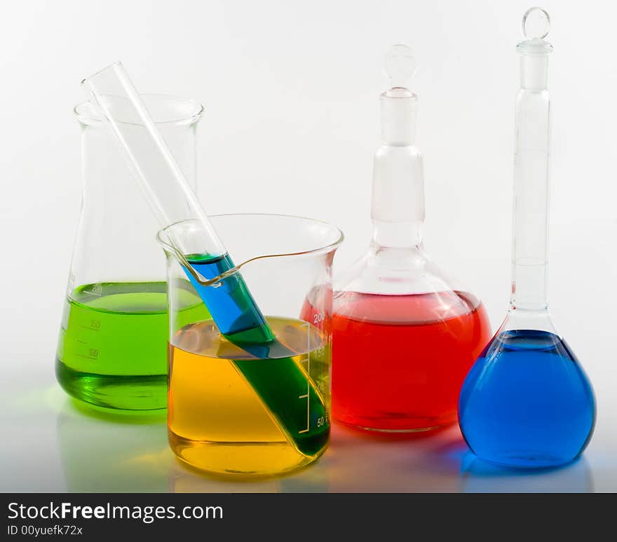 Various colorful glass flasks over white background. Various colorful glass flasks over white background