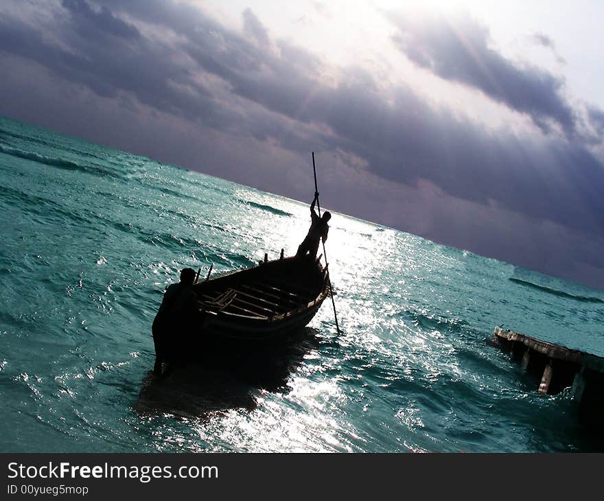 A single fisherman rowing his boat in the sea for fishing. A single fisherman rowing his boat in the sea for fishing