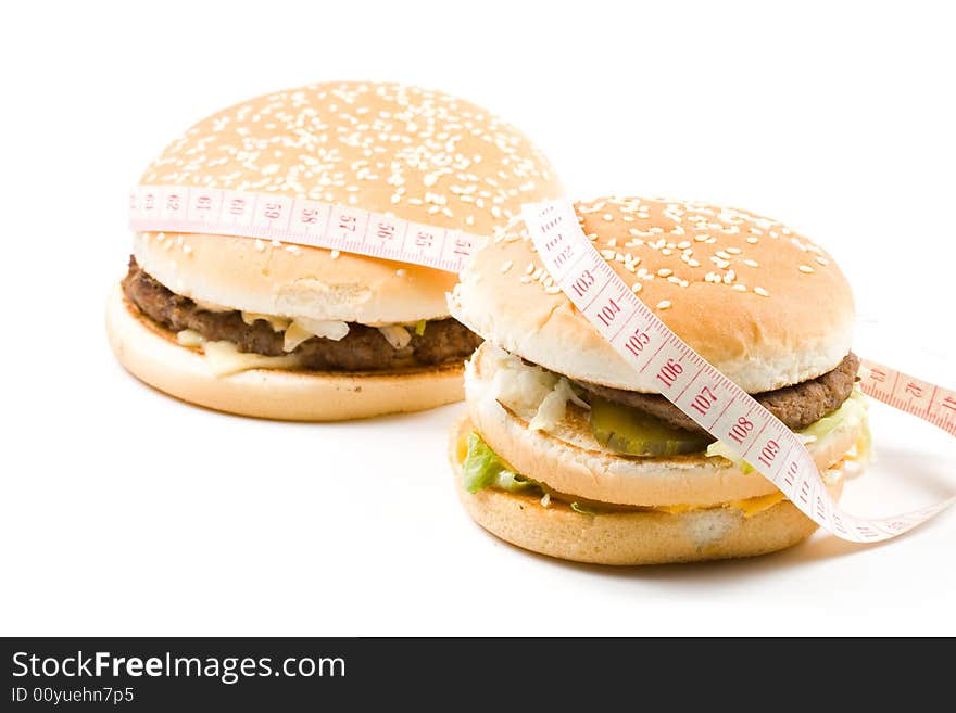 Bread with fried meat, cheese, onion, lettuce and measuring tape isolated on a white background. Bread with fried meat, cheese, onion, lettuce and measuring tape isolated on a white background.