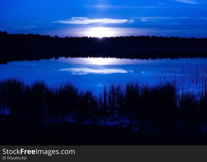 Photo. Sunset over the lake, reflected in the water.