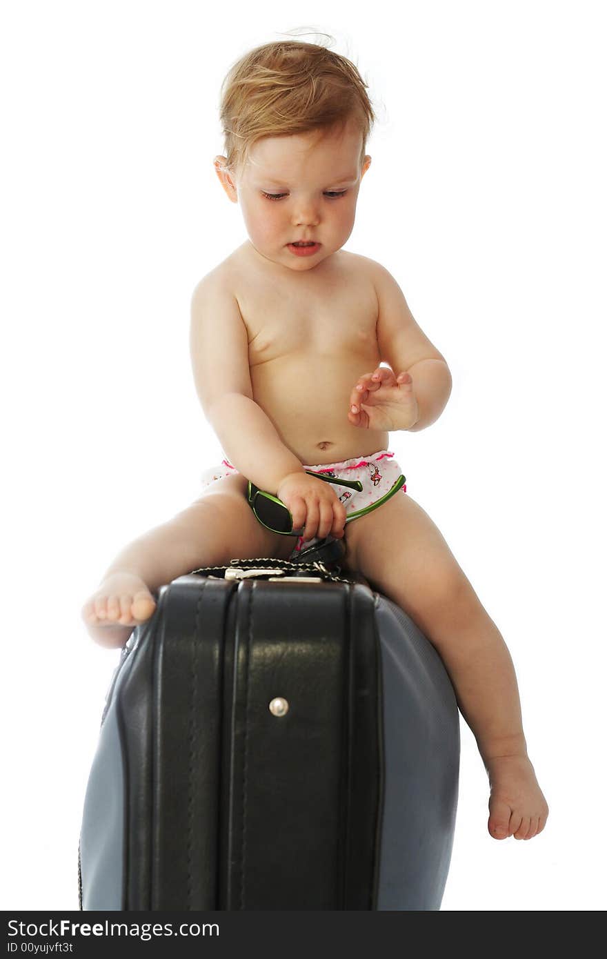 A baby with goggles sitting on a valise. A baby with goggles sitting on a valise