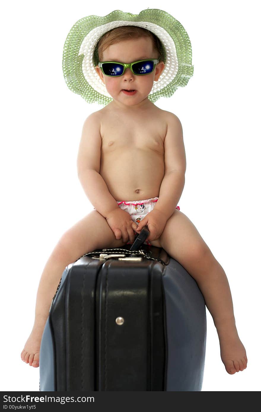 A baby with hat and goggles on a valise. A baby with hat and goggles on a valise