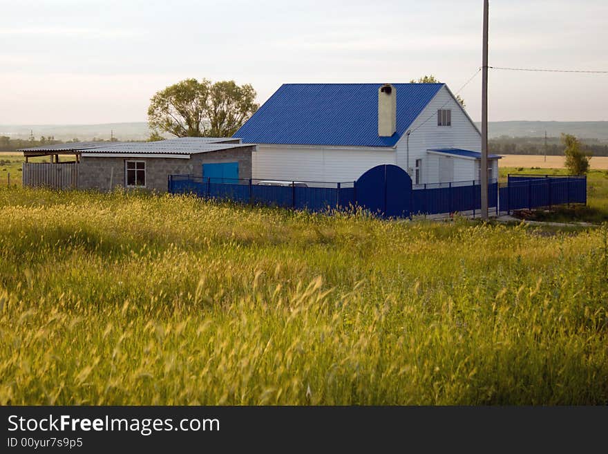 Small house in village with a dark blue roof