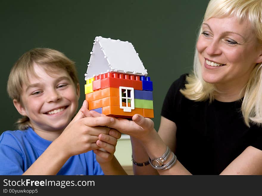 The woman and the boy hold a toy small house