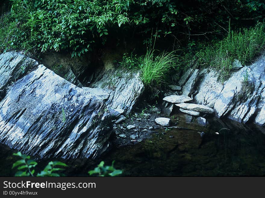 Stream with several rocks on the stream bank. Stream with several rocks on the stream bank.