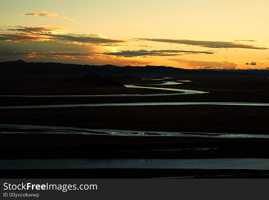 When travelling in Tibet of China in autumn,   headwaters Yellow River on the meadows appear in front of us, with sunset. When travelling in Tibet of China in autumn,   headwaters Yellow River on the meadows appear in front of us, with sunset.