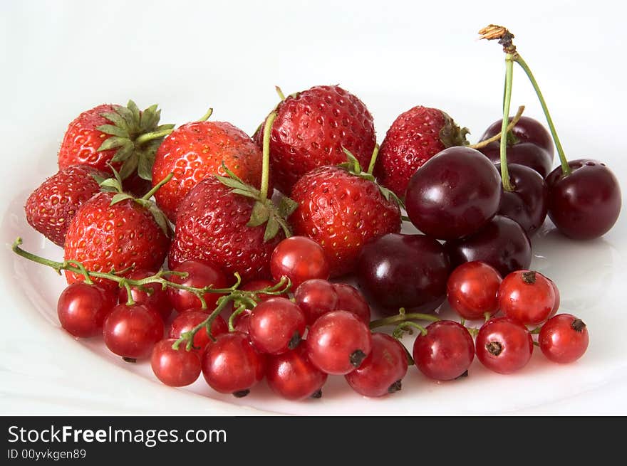 Strawberry, cherry and currant on a white plate. Strawberry, cherry and currant on a white plate