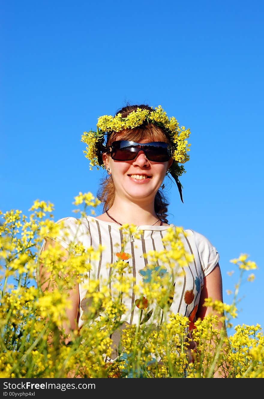 Beautiful girl and yellow flowers over a blue sky