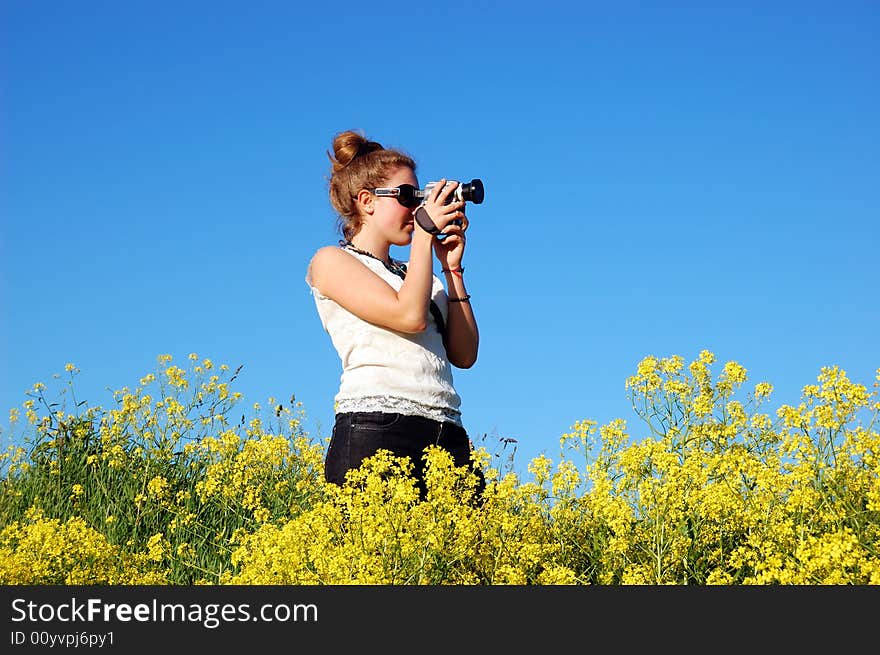 Beautiful girl with camera over a blue sky