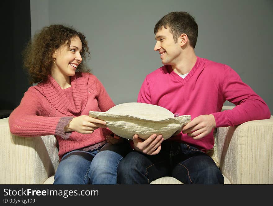 Couple Sit On Sofa With Pillow