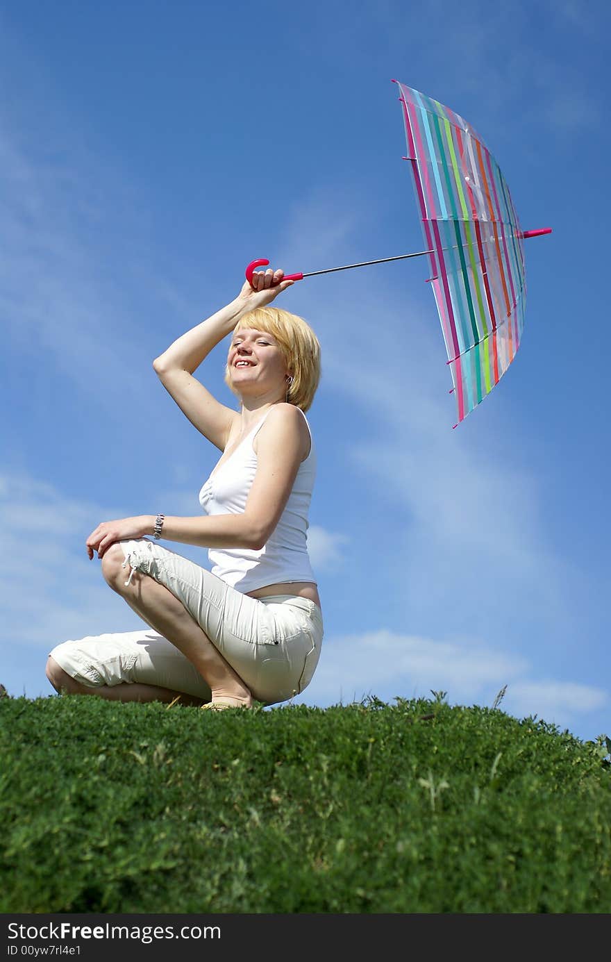 Young charming girl with umbrella against blue sky