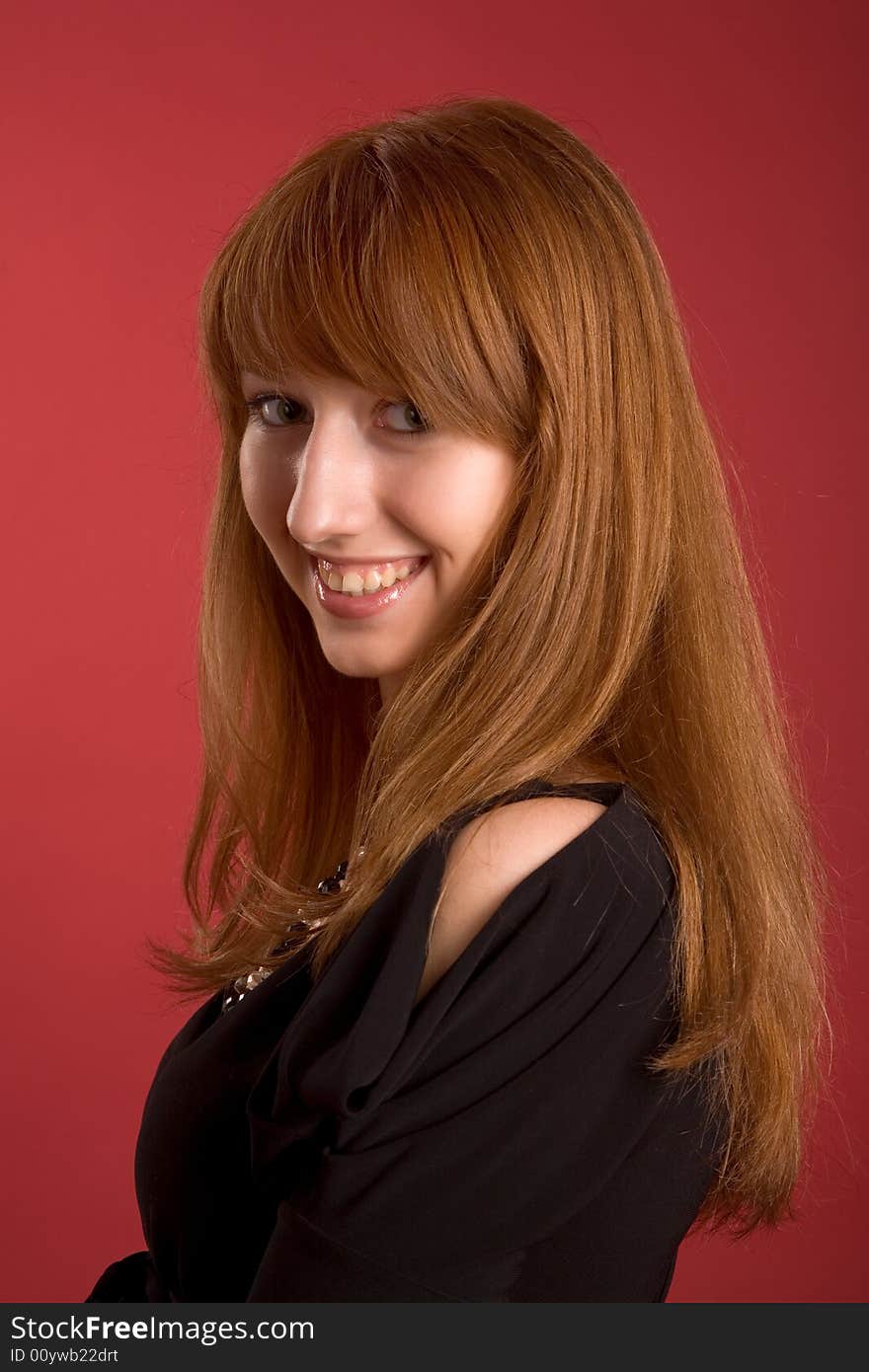 Beautiful smiling girl isolated on red background