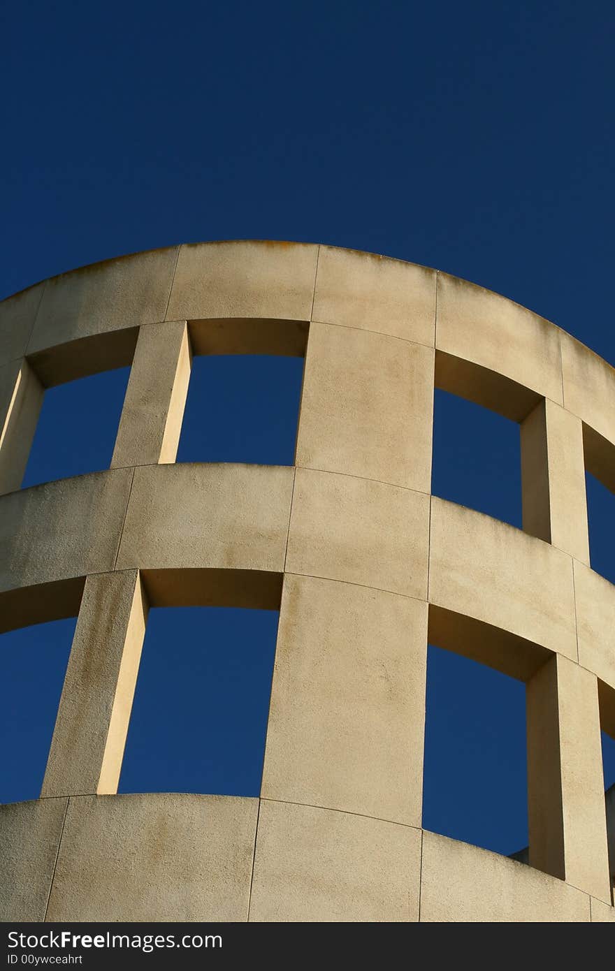 A curved wall in front of a blue sky.