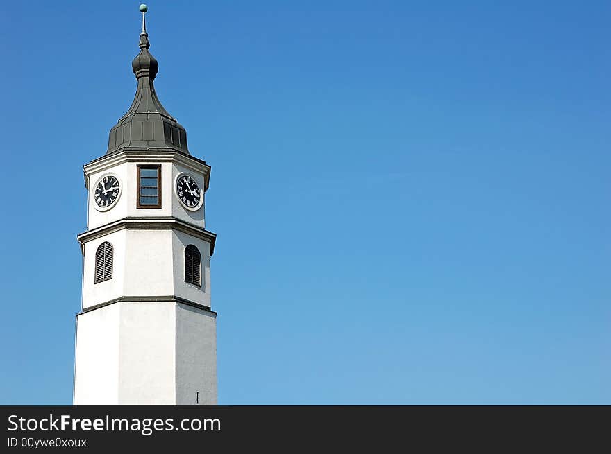 White tall clock tower against blue sky