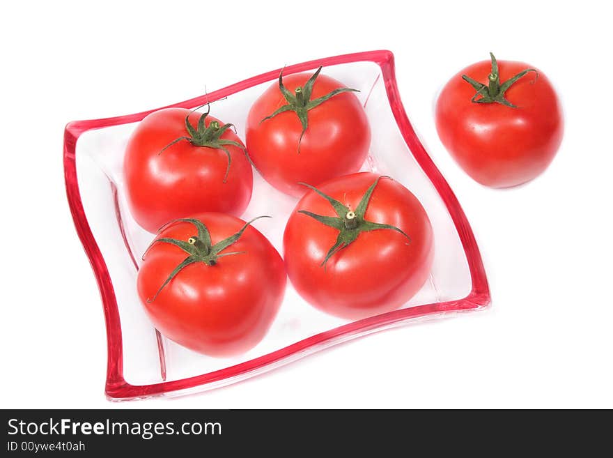 Red tomatoes on a glass plate,isolated. Red tomatoes on a glass plate,isolated.