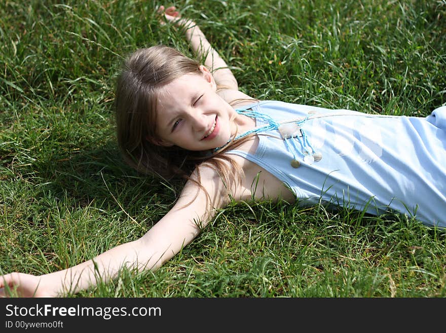 Young girl laying on the green grass