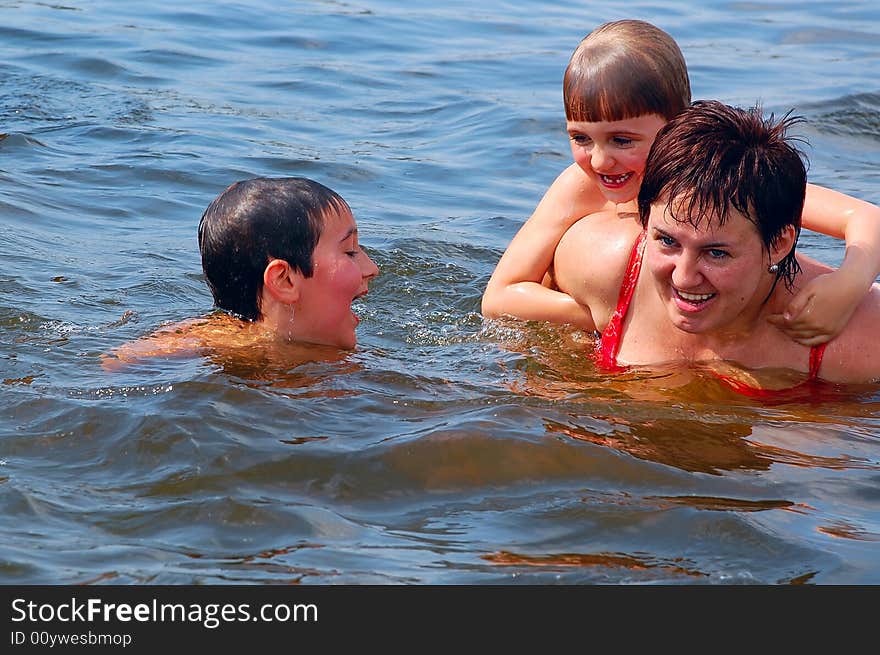 Mother and her two children having water fun. Mother and her two children having water fun