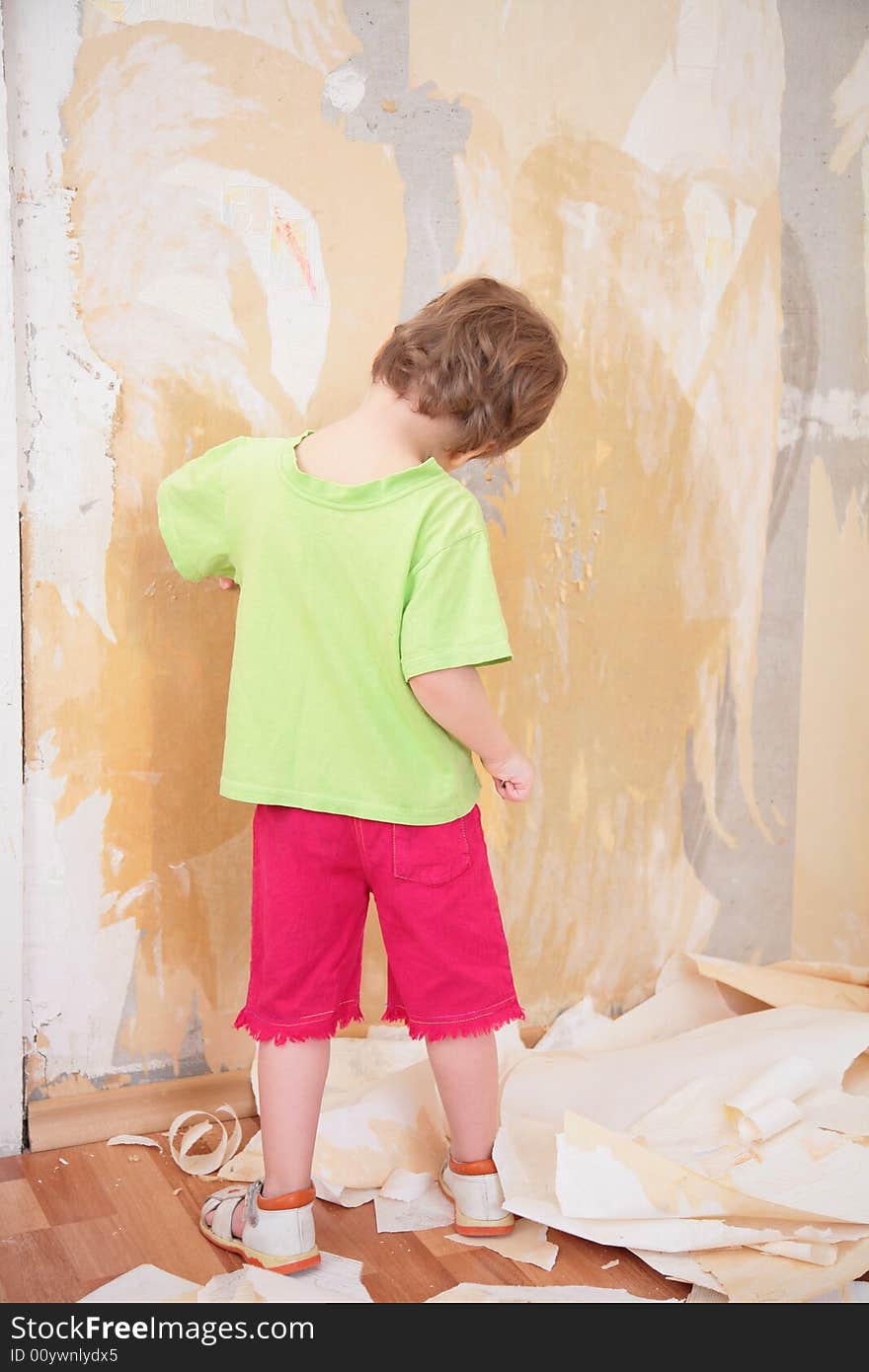 A little girl remove old wallpapers