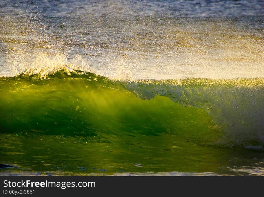 Sunlit spray from a green wave on the Atlantic ocean off the west coast of South Africa. Sunlit spray from a green wave on the Atlantic ocean off the west coast of South Africa.