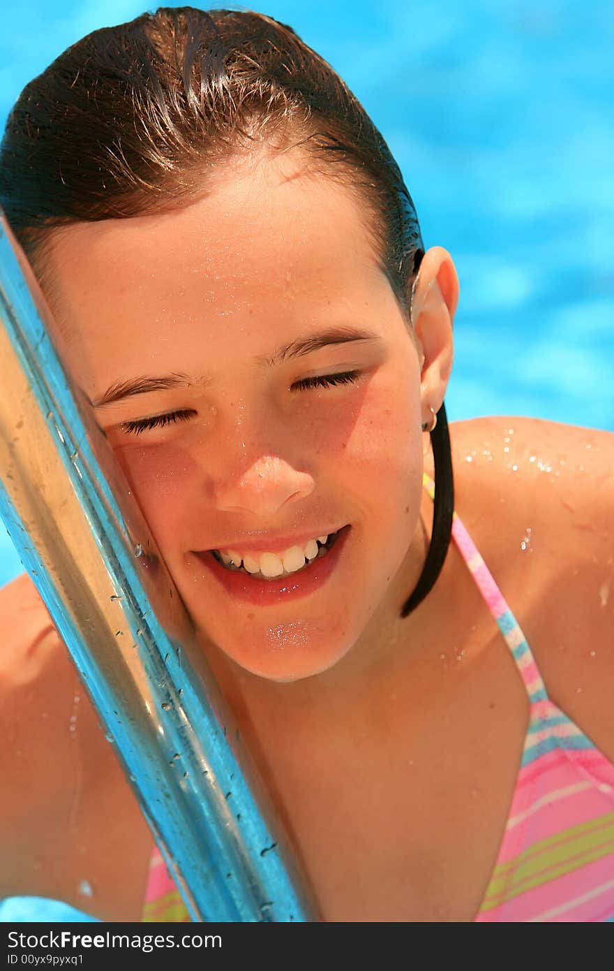 Young girl in the pool, smiling and happy